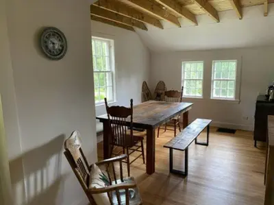 a dining room with a wooden table and chairs at Le Highwater - Cabin in Mansonville