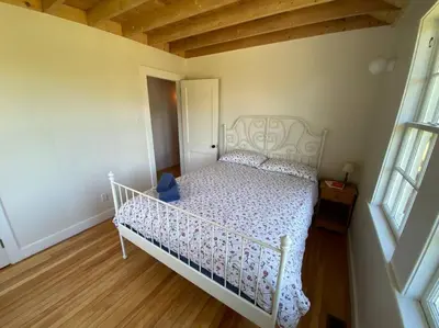 a bedroom with a white bed in a room at Le Highwater - Cabin in Mansonville