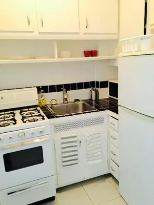 a kitchen with white appliances and a sink at Stylish Montreal Apartment: Comfortable Stay in the Golden Square Mile in Montréal