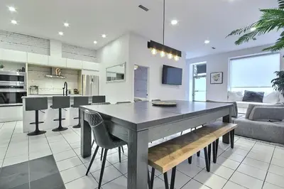 a kitchen and living room with a table and chairs at L'exclusif du Plateau in Montréal