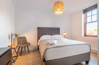 a bedroom with a bed and a desk and a chair at L'exclusif du Plateau in Montréal