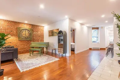 a living room with a brick wall and a piano at L'exclusif du Plateau in Montréal