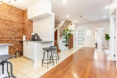 an open kitchen and living room with a brick wall at L'exclusif du Plateau in Montréal
