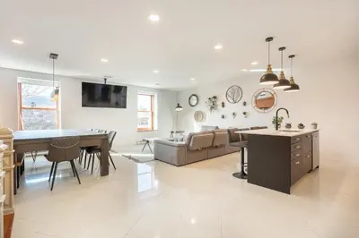a kitchen and living room with a table and a couch at L'exclusif du Plateau in Montréal