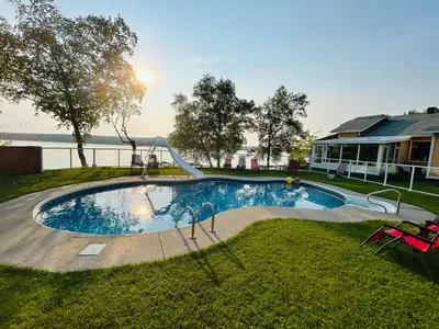 a swimming pool with a slide in a yard at Auberge et Chalets sur le Lac in Lac-Mégantic