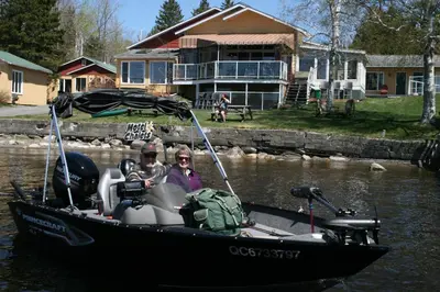 two people in a boat in the water at Auberge et Chalets sur le Lac in Lac-Mégantic