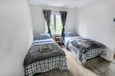 a bedroom with two beds and a window at Appartment 2BR 4 beds AC wi-Fi Smart TV FreeParking in Laval