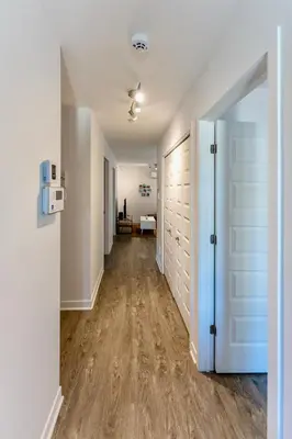 a hallway with white doors and wood floors at Appartment 2BR 4 beds AC wi-Fi Smart TV FreeParking in Laval