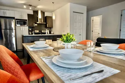 a wooden table with bowls and plates on it in a kitchen at Peaceful Getaway in Laval