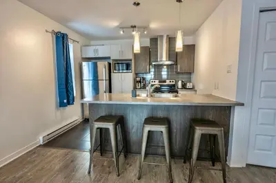 a kitchen with a counter and stools in a kitchen at Peaceful Getaway in Laval