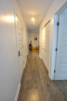 an empty hallway with white doors and wood floors at Peaceful Getaway in Laval