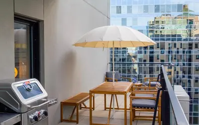 a table and chairs with an umbrella in front of a window at Stuning penthouse old montreal in Montréal
