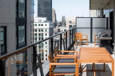 a balcony with a wooden table and chairs on a building at Stuning penthouse old montreal in Montréal