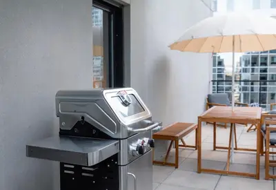 a grill in a room with a table and an umbrella at Stuning penthouse old montreal in Montréal
