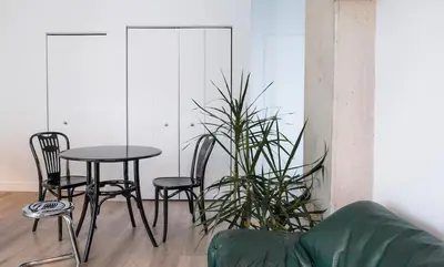 a table and chairs in a living room with a plant at Stuning penthouse old montreal in Montréal