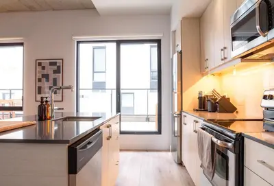 a kitchen with stainless steel appliances and a large window at Stuning penthouse old montreal in Montréal