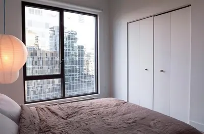 a bedroom with a bed and a large window at Stuning penthouse old montreal in Montréal
