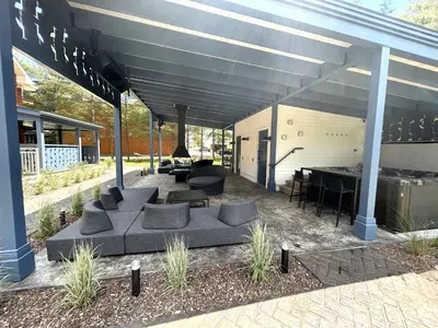 a covered patio with couches and a pool table at Le Héron - Studios Nature in Magog-Orford