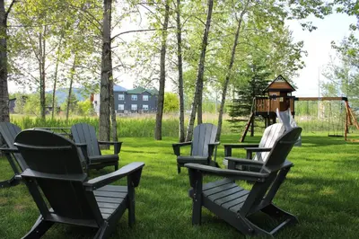 a group of chairs in a yard with a playground at Le Héron - Studios Nature in Magog-Orford