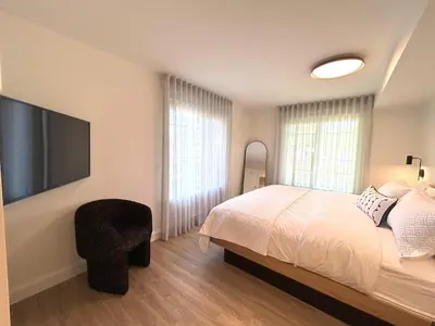 a bedroom with a bed and a flat screen tv at Le Héron - Studios Nature in Magog-Orford