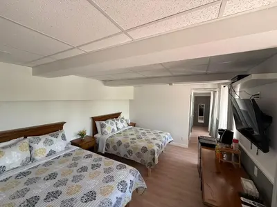 a bedroom with two beds and a flat screen tv at Hostellerie du Suroît in Beauharnois