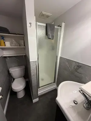 a bathroom with a shower and a toilet and a sink at Hostellerie du Suroît in Beauharnois