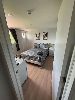 a small bedroom with a bed and a desk at Hostellerie du Suroît in Beauharnois