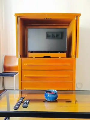 a tv sitting on top of a wooden dresser at Stylish Montreal Apartment Comfortable Stay in the Golden Square Mile in Montréal
