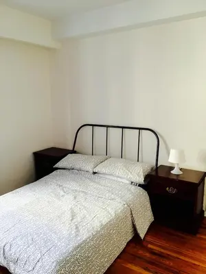 a bedroom with a bed and a table with a lamp at Stylish Montreal Apartment Comfortable Stay in the Golden Square Mile in Montréal