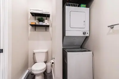 a small bathroom with a toilet and a washer and dryer at Appartement Sur la 