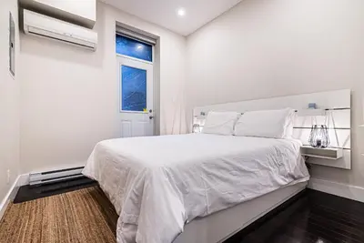 a white bedroom with a large bed and a window at Appartement Sur la 