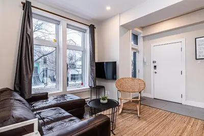 a living room with a leather couch and a window at Appartement Sur la 
