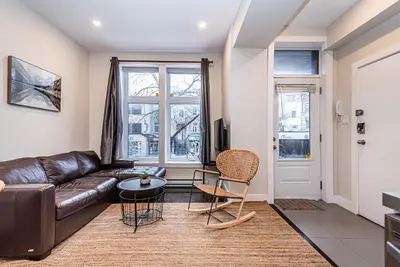 a living room with a leather couch and a table at Appartement Sur la 