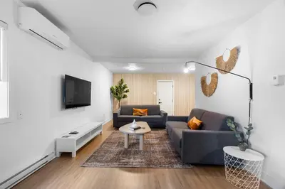 a living room with a couch and a tv at Hotel Laurence in Montréal