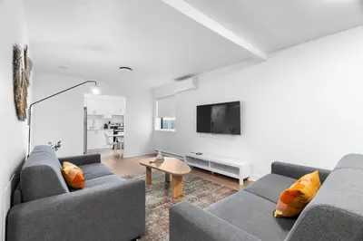 a living room with two couches and a tv at Hotel Laurence in Montréal