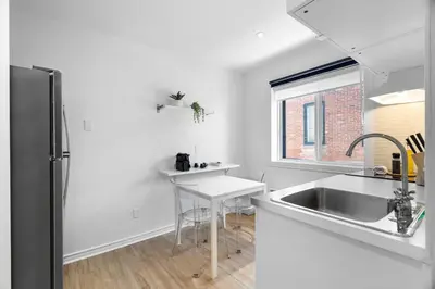 a white kitchen with a sink and a counter at Hotel Laurence in Montréal