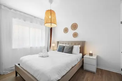 a white bedroom with a bed and a window at Hotel Laurence in Montréal