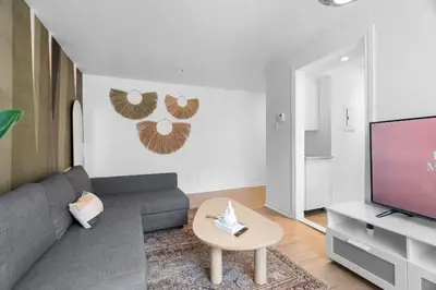 a living room with a couch and a tv at Hotel Laurence in Montréal