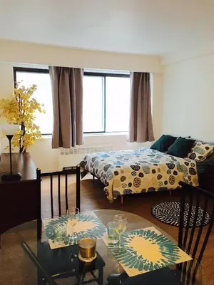 a living room with two beds and a glass table at Stylish Montreal Apartment: Comfortable Stay in the Golden Square Mile in Montréal