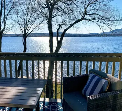 a couch sitting on a deck with a view of a lake at OMagogcondo com A in Magog-Orford