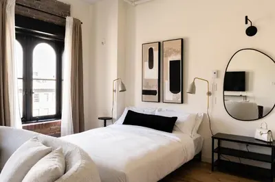 a bedroom with a large white bed and a mirror at Maison Place Jacques-Cartier by Luxury In Transit in Montréal