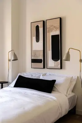 a bedroom with a white bed with three pictures on the wall at Maison Place Jacques-Cartier by Luxury In Transit in Montréal