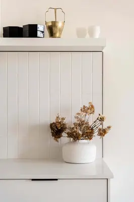 a white cabinet with a vase with flowers in it at Maison Place Jacques-Cartier by Luxury In Transit in Montréal