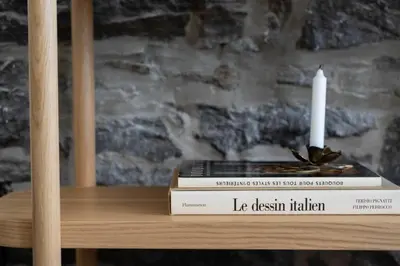 a stack of books sitting on a table with a candle at Maison Place Jacques-Cartier by Luxury In Transit in Montréal