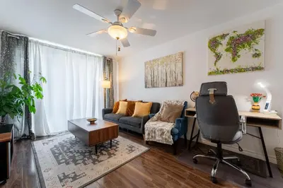 a living room with a couch and a desk at Cozy Family Home Near Montreal in Brossard