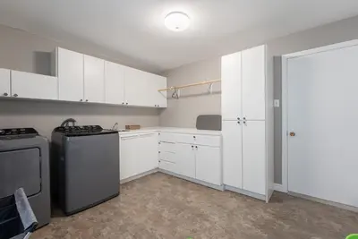 a kitchen with white cabinets and a black refrigerator at Cozy Family Home Near Montreal in Brossard