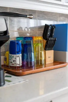 a wooden tray with different colored cups and utensils at Cozy Family Home Near Montreal in Brossard