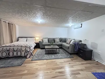 a living room with a couch and a bed at Cozy Family Home Near Montreal in Brossard