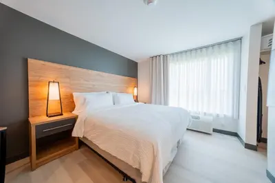 a bedroom with a large bed and a large window at Candlewood Suites Trois-Rivières Ouest by IHG in Trois-Rivières