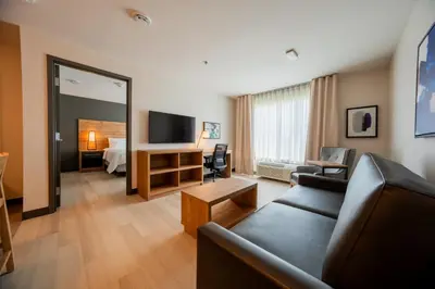 a living room with a couch and a tv and a bed at Candlewood Suites Trois-Rivières Ouest by IHG in Trois-Rivières